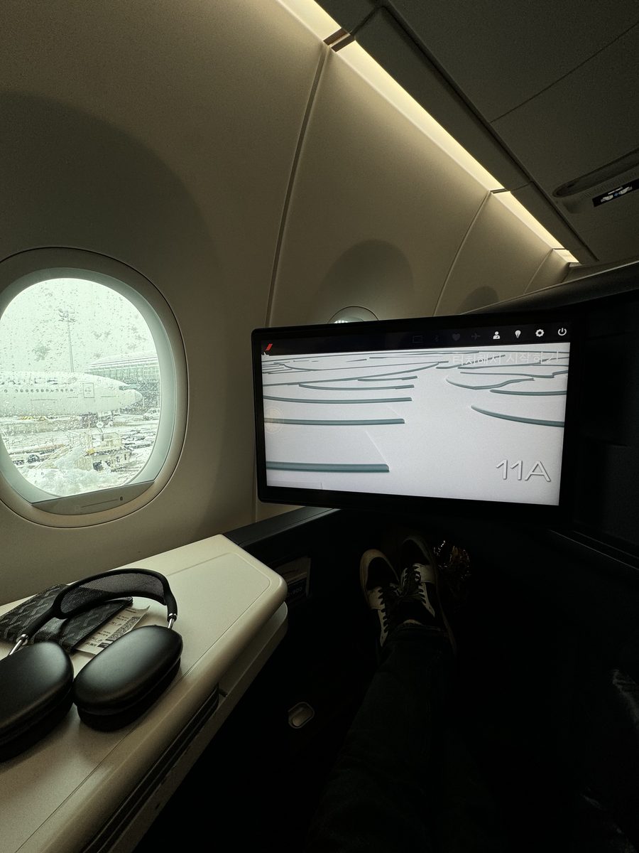 L'écran 17 pouces 4K de la nouvelle suite business Air France affichant le numéro de siège 11A, casque Apple posé sur la console