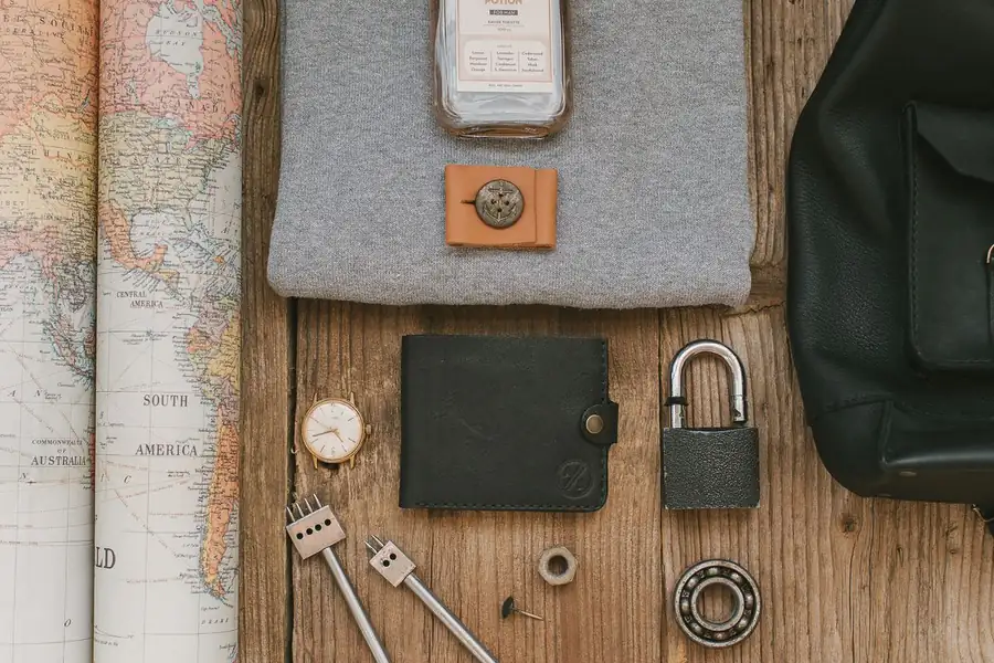 Carte du monde, montre et accessoires de voyage disposés avec soin