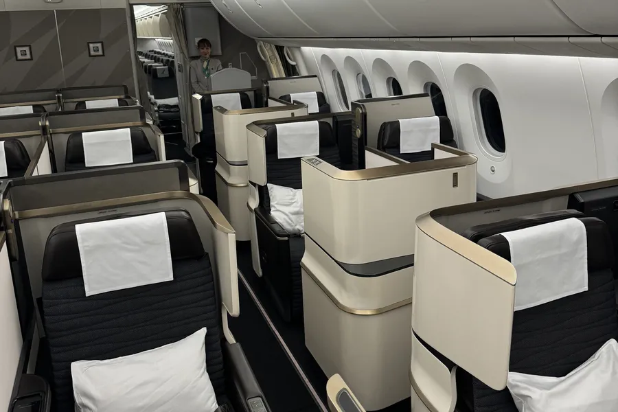 La cabine business du Boeing 787-9 de Gulf Air avec ses Apex Suites beiges et or, oreillers blancs sur chaque siège