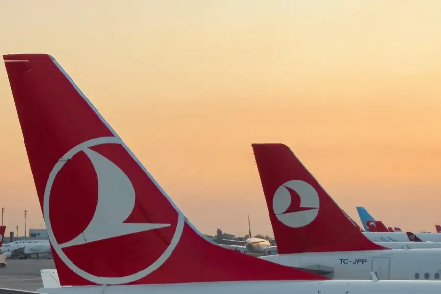 Empennages rouge et blanc d'avions Turkish Airlines au coucher du soleil sur le tarmac d'Istanbul