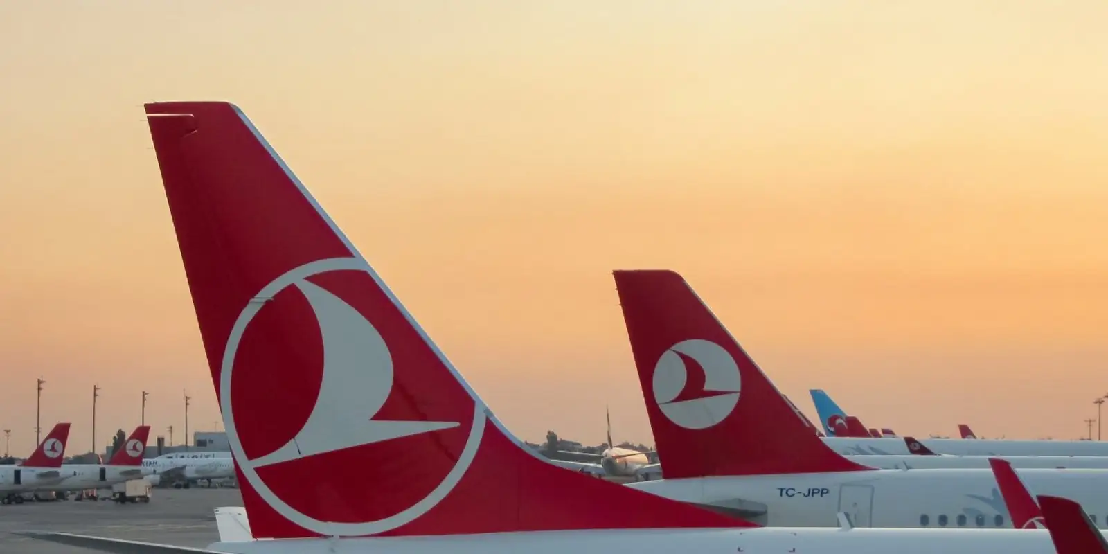 Empennages rouge et blanc d'avions Turkish Airlines au coucher du soleil sur le tarmac d'Istanbul