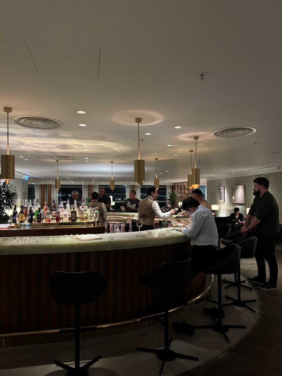Le bar en onyx et ses lampes en laiton du salon The Pier First Class Lounge de Cathay Pacific à Hong Kong