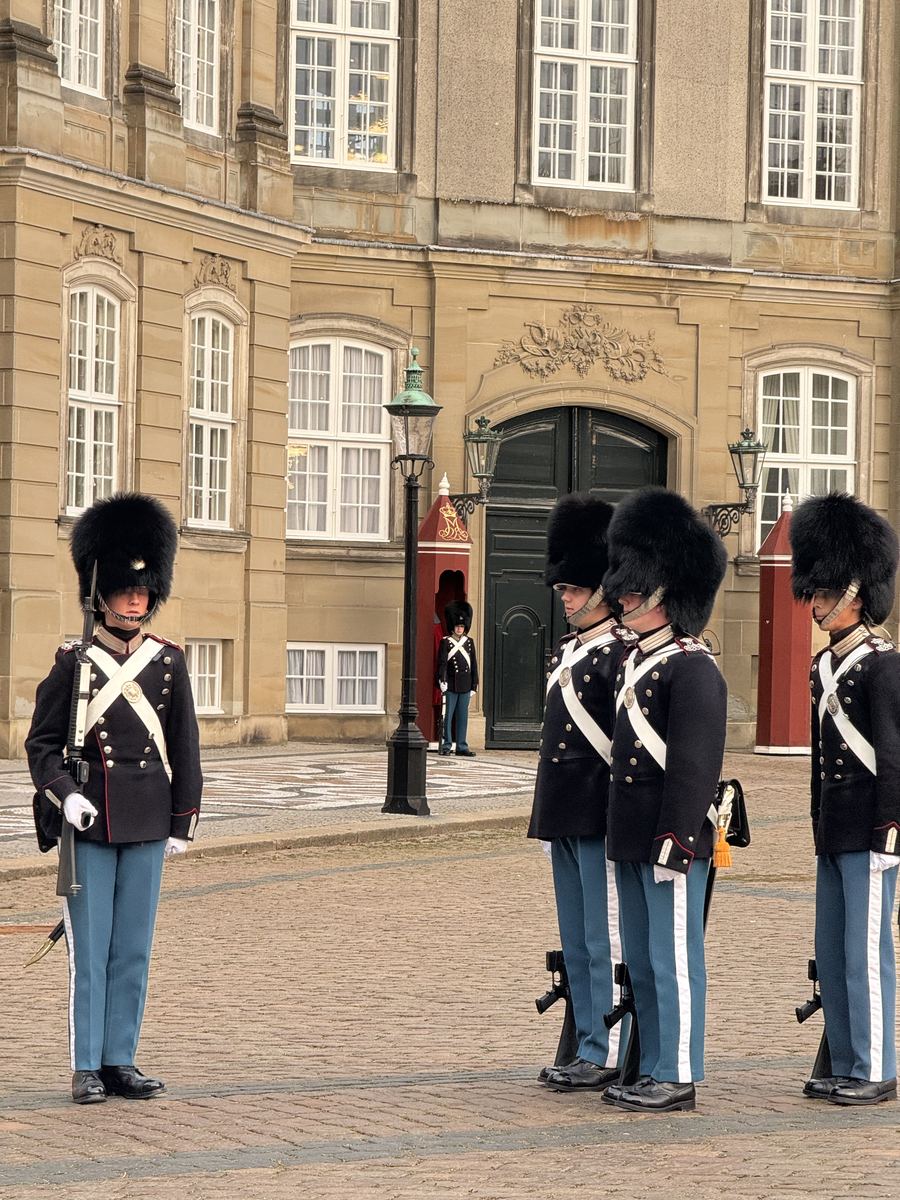 Gardes royaux danois alignés devant une guérite rouge du palais d'Amalienborg lors de la relève de la garde