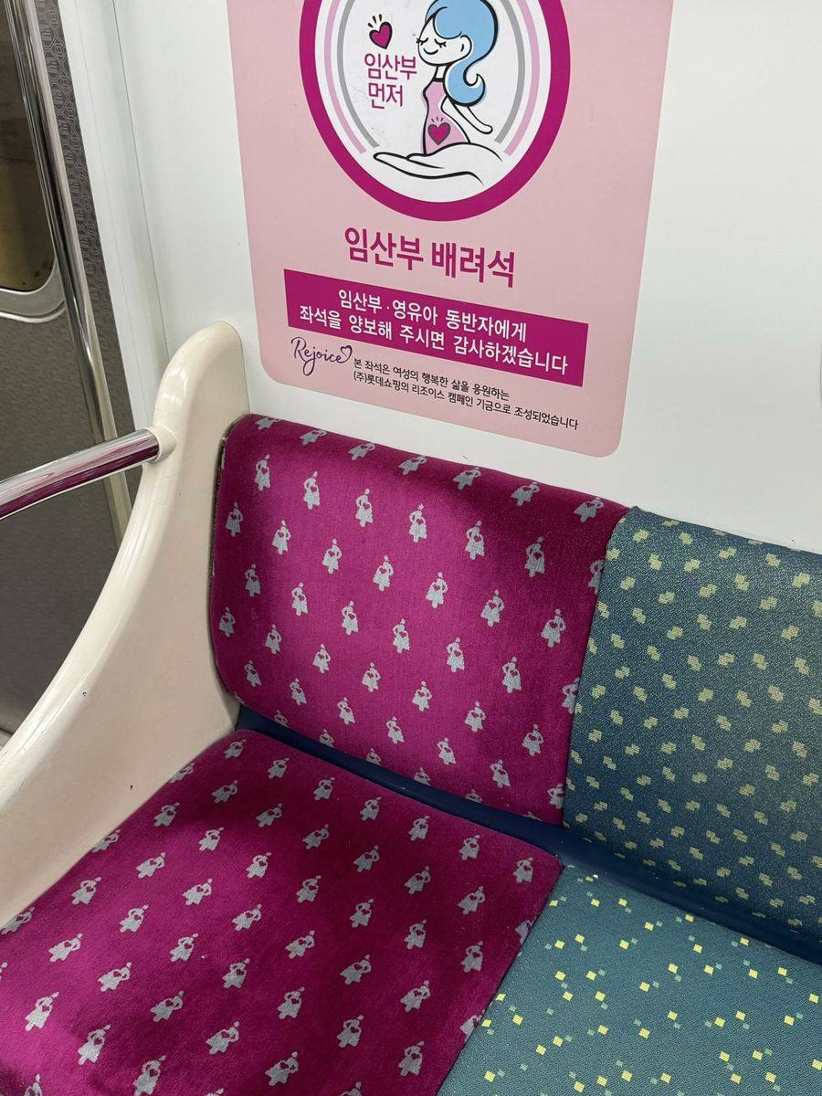 Siège rose du métro de Séoul réservé aux femmes enceintes, avec l'autocollant explicatif rose au-dessus du dossier