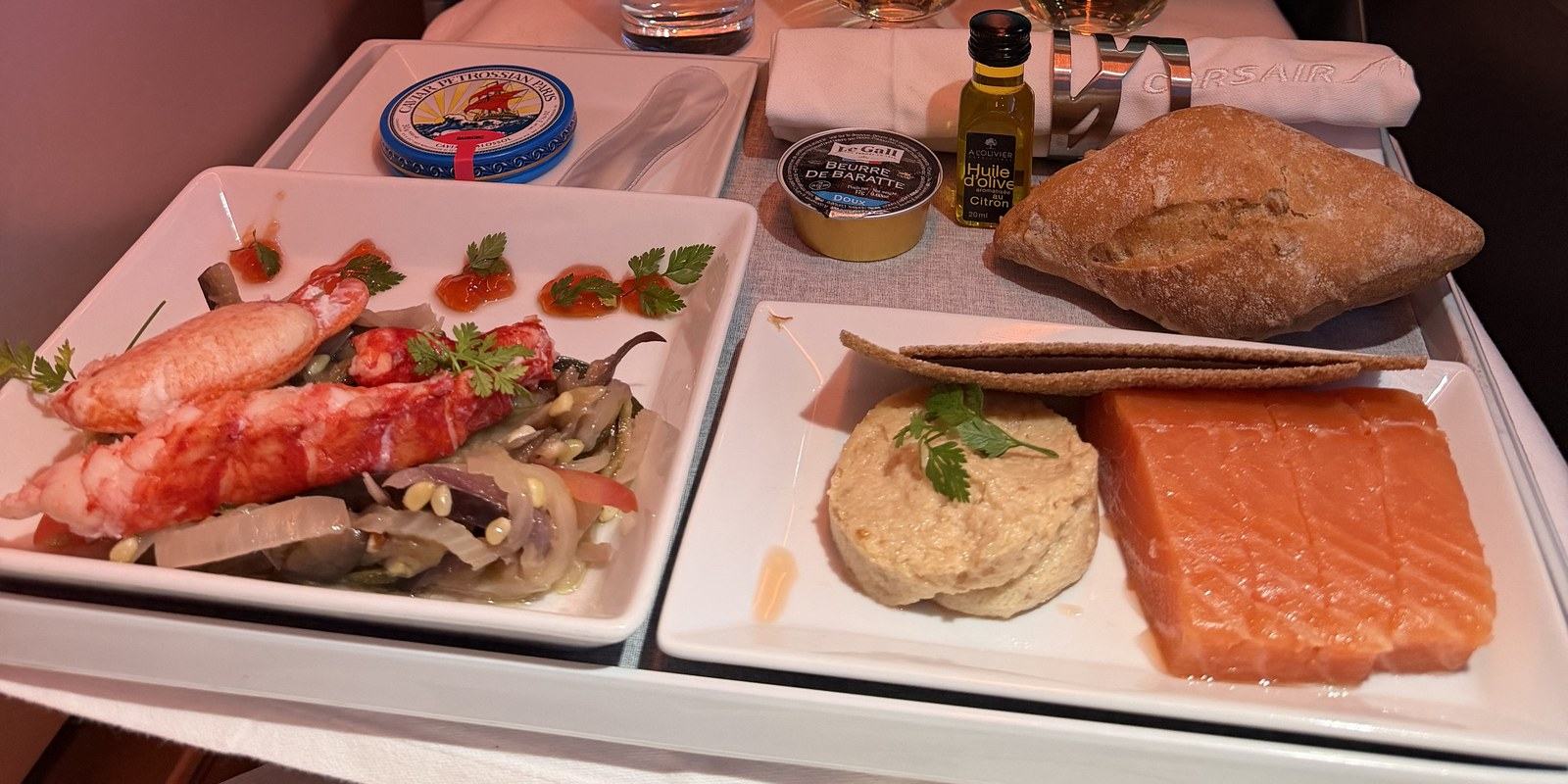 Menu Prestige de Corsair avec caviar Petrossian, homard et saumon fumé sur un plateau de classe affaires