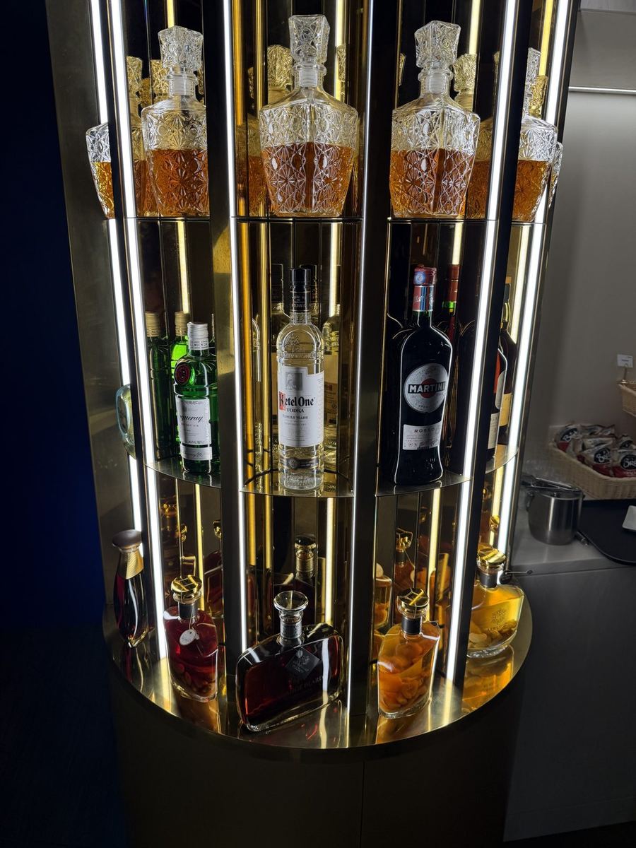 Colonne bar dorée à miroirs du salon Corsair, éclairée par des néons verticaux, avec carafes en cristal et rhums arrangés réunionnais