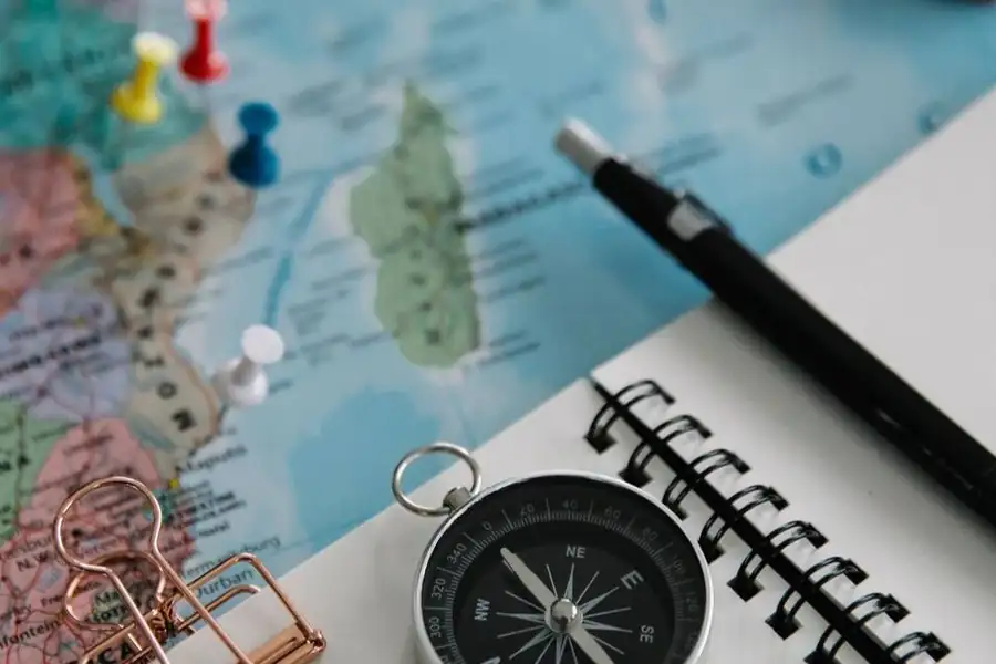 Carte, boussole et carnet de voyage posés sur une table